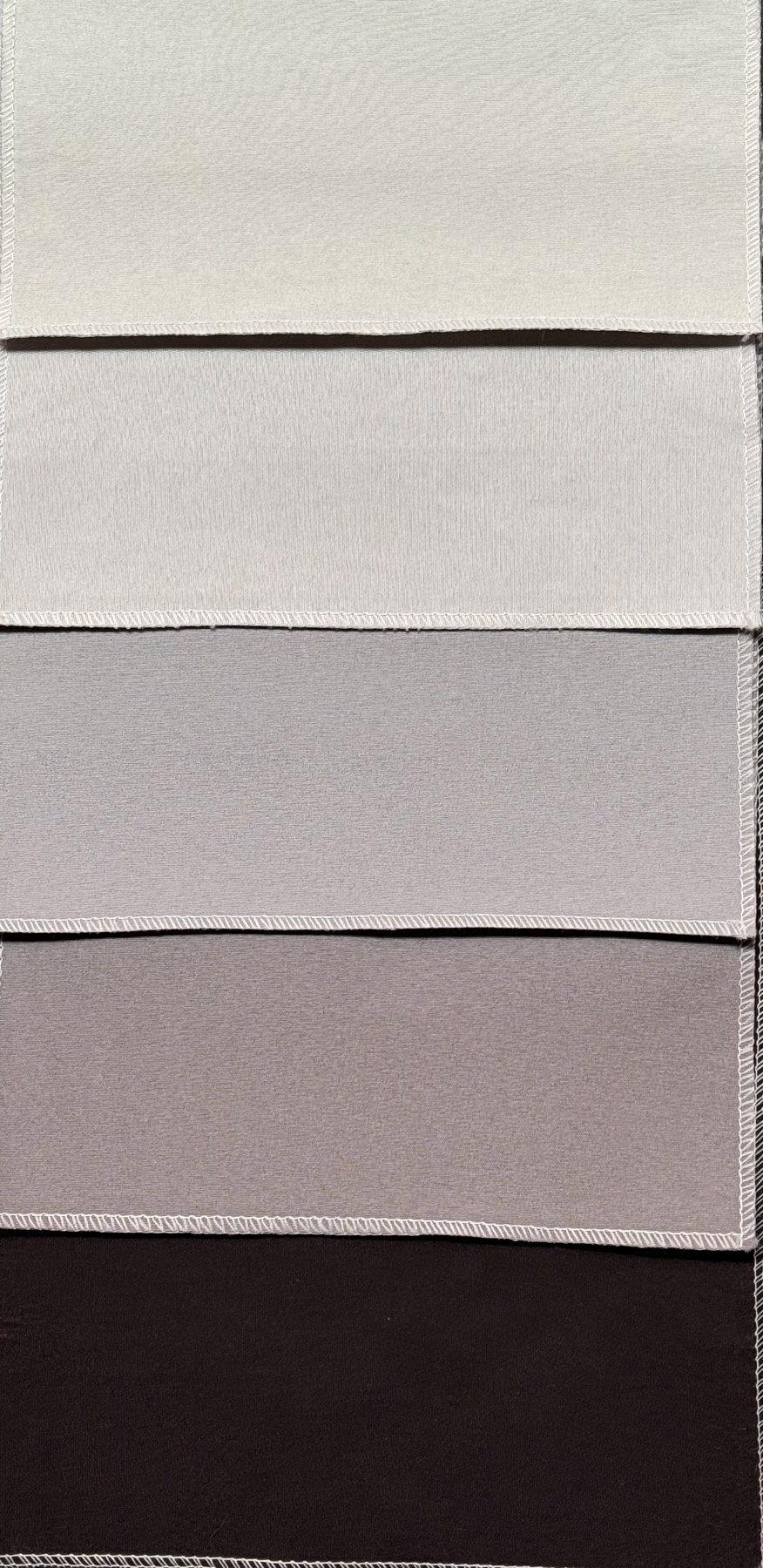 Muestrario Línea Melody de telas blackout para riel europeo en natural, blanco, gris claro, gris oscuro y negro